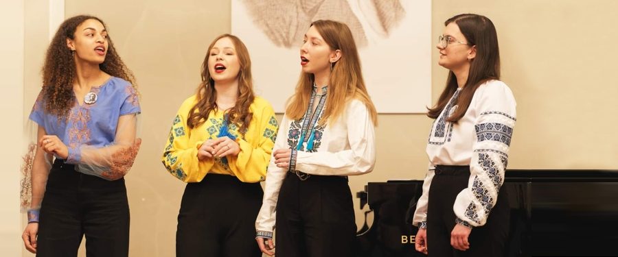 Cztery młode kobiety śpiewają podczas koncertu.