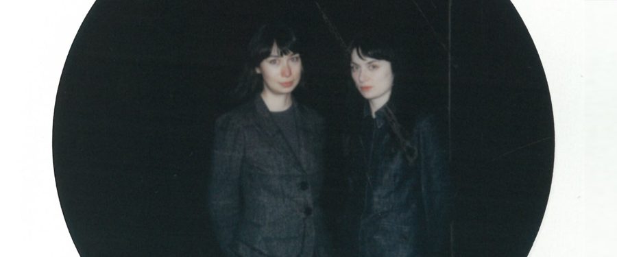 Polaroidowe zdjęcie dwóch kobiet na ciemnym tle, w kształcie wycinka koła.