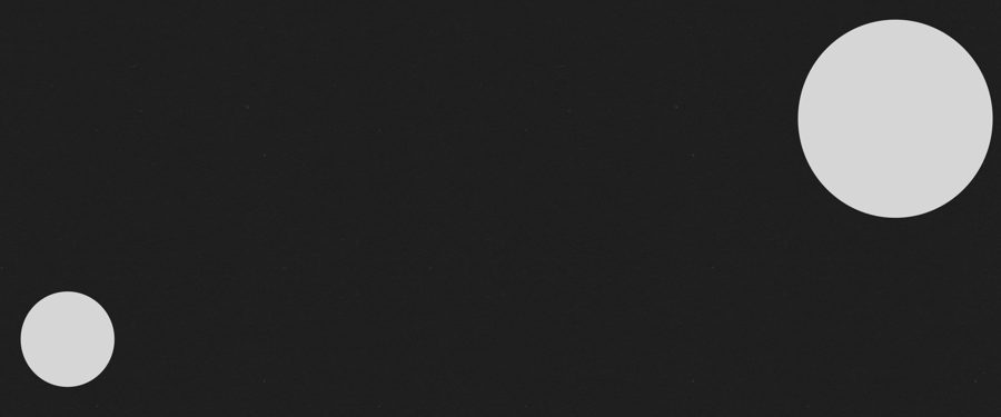 dwa jasno szare koła na czarnej planszy, większe koło w górnym prawym narożniku, mniejsze w dolnym, lewym.